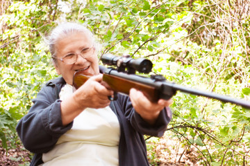 Grandmother with rifle. Grandmother in hunt with rifle in woods