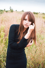 Girl in field. Portrait of beautiful girl in knitted dress