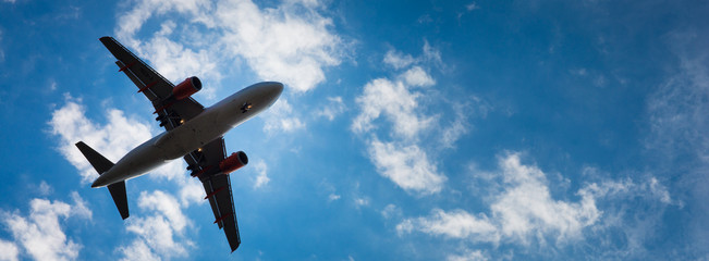 Dark silhouette of an airplane flying over the blue skies