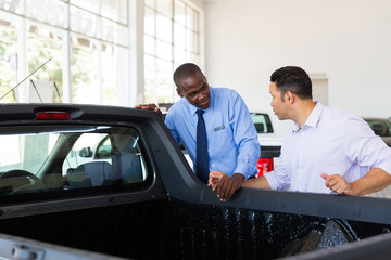 car salesman selling a car to middle aged customer