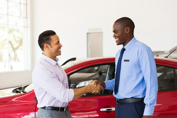 african american car dealer handshake with customer