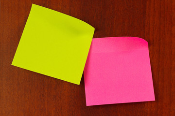 Red and green stickers on a wooden board from notice