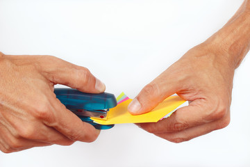 Hands bonded colored paper stapler on a white background