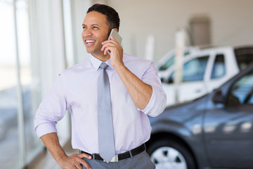 car salesman talking on cell phone