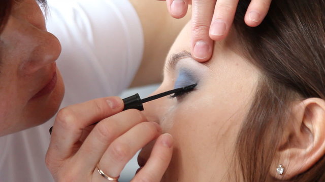 Makeup artist applying black eye liner to model eye. Full HD