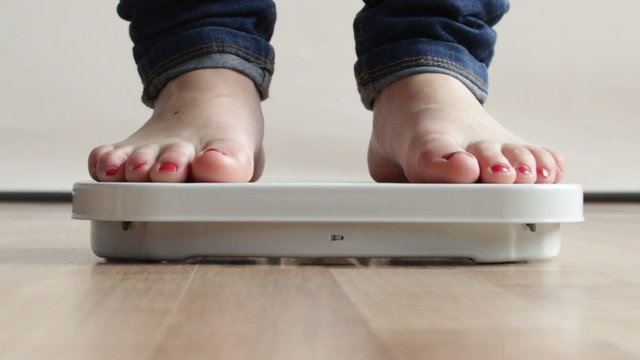 Diet weight loss. Woman stepping on scales