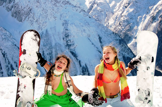 Girls snowboarders in bikinis in the mountains