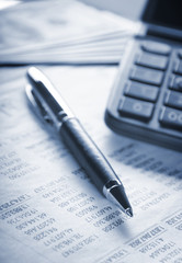 Calculator, pen and money on financial statement