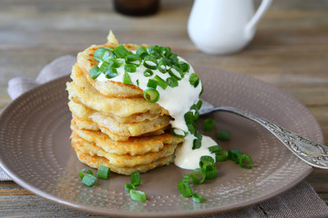 Potato pancakes with sour cream and green onions