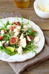 salad with arugula, figs, pears and slices of cheese on a plate