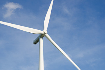 wind turbine against cloudy blue sky background