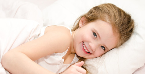 Obraz na płótnie Canvas Adorable smiling little girl waked up