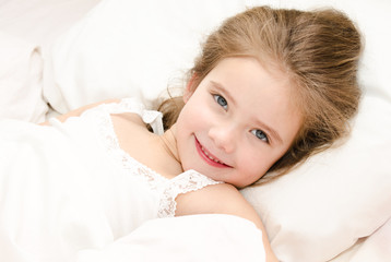 Obraz na płótnie Canvas Adorable smiling little girl waked up