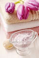 Fototapeta na wymiar Spa set: bouquet of tulips on a towel, sea salts and bar of soap