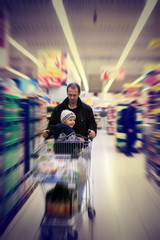 Fototapeta na wymiar Adorable little boy, sitting in a shopping cart