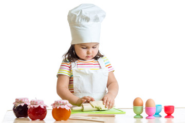little baker kid girl in chef hat at kitchen
