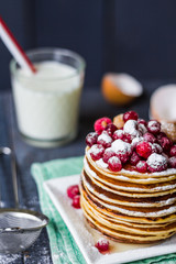 Pancake with cranberries, raspberries, honey and powdered sugar