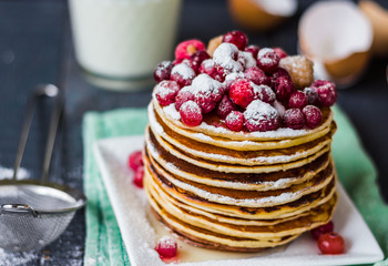 Pancake with cranberries, raspberries, honey and powdered sugar