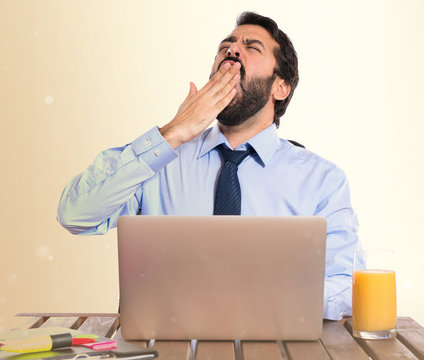 Businessman yawning in his office