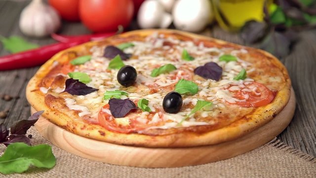 Unrecognizable woman is putting olives on pizza margherita
