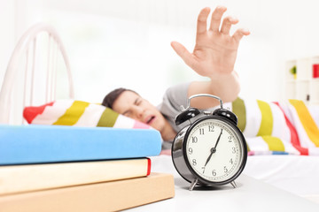 Sleepy man reaching for the alarm clock