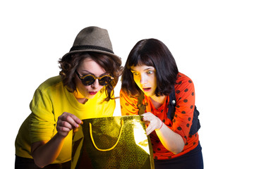 two women open bag with surprise