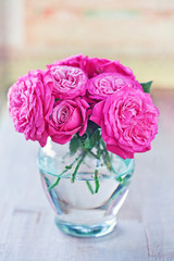 Beautiful fresh roses in a vase on a table.
