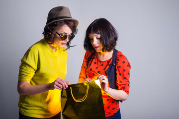 two women open bag with surprise