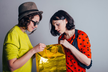 two women open bag with surprise