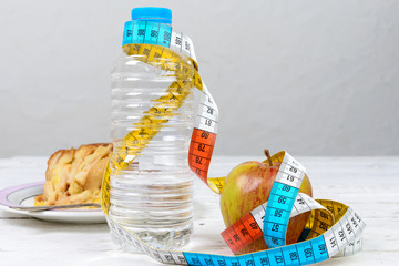 bottle of water and an apple with a measuring tape