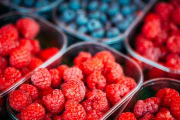 Baskets Full Of Raspberries And Blueberries On The Farmers Marke