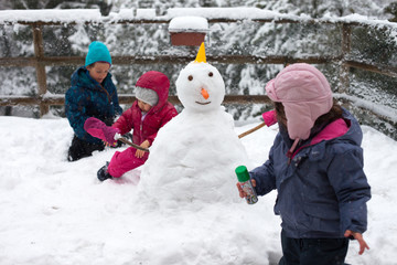 Fototapeta na wymiar Bambini e il pupazzo di neve