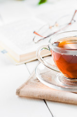 cups of tea with book on wooden table