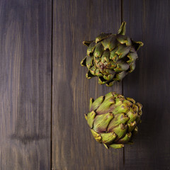 Fototapeta premium few artichokes on a wooden black table