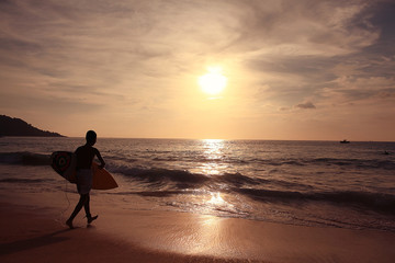 Fototapeta premium sunset on the beach silhouettes of people