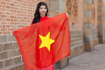 Pretty young Vietnamese woman holding a flag