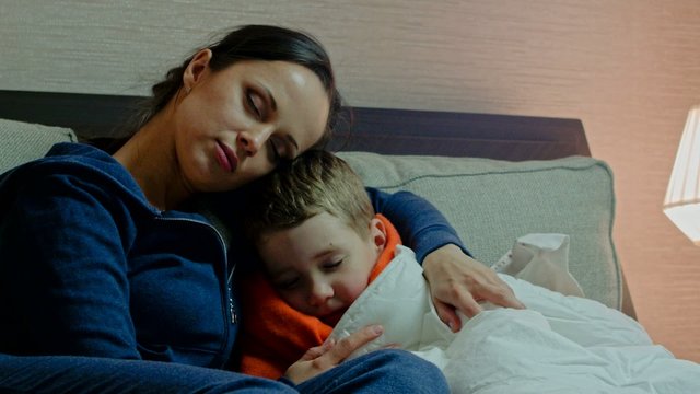 Young mother and her sick son in a bed