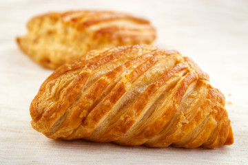 Warm baked apple pies on white table mat