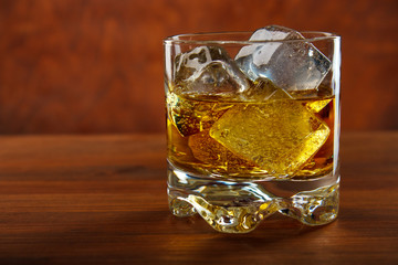 Whiskey on the rocks on wooden table