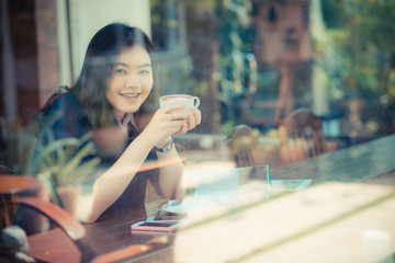 Young asian woman hold coffee cup and smiling