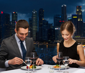 smiling couple eating main course at restaurant
