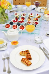 Table set up for continental breakfast: muesli, fruits