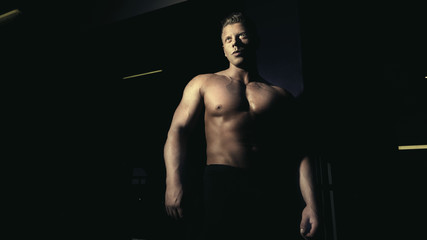 Fototapeta na wymiar Young bodybuilder posing in a gym