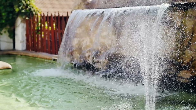 artificial waterfall with fountain in the garden slow motion