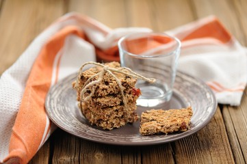 Granola bars with empty glass on wooden background