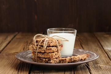 Granola bars with glass of milk on wooden background