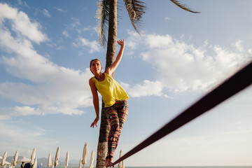 teenage girl  balancing on slackline with sky view