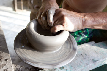 Fototapeta na wymiar hands of a potter manufactures clay pot
