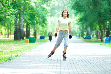 Roller skating sporty girl in park rollerblading on inline skate