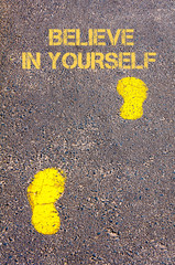 Yellow footsteps on sidewalk towards Believe in yourself message